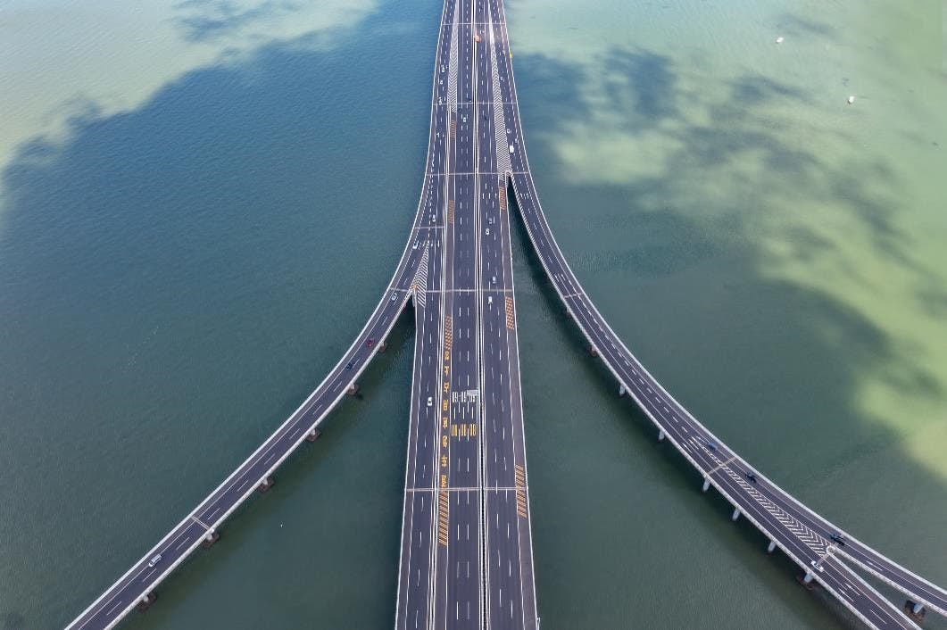 A bridge with multiple lanes coming together over water