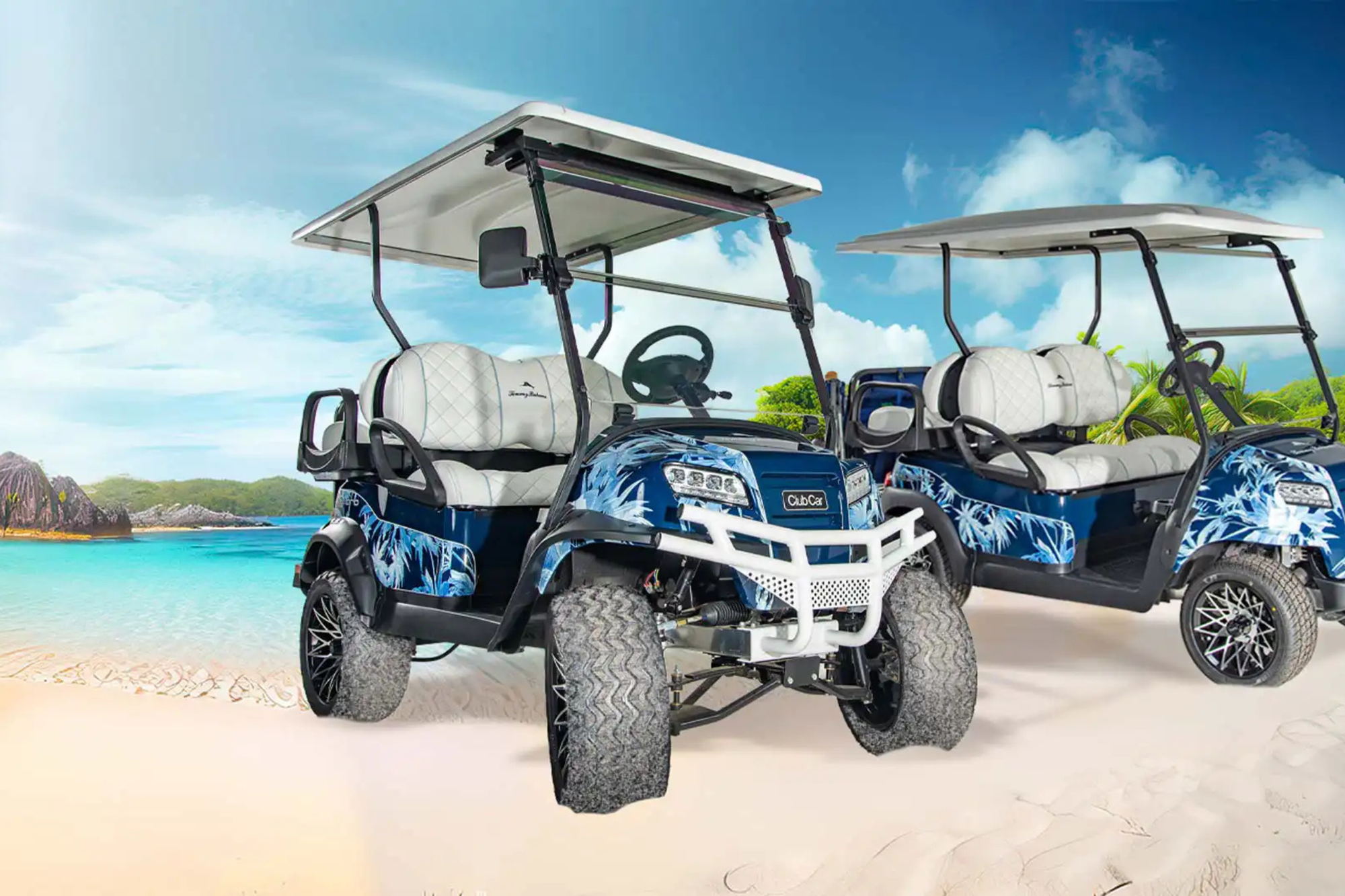 Two Tommy Bahama® Club Car Onward® Special Edition golf carts are parked in the sand.