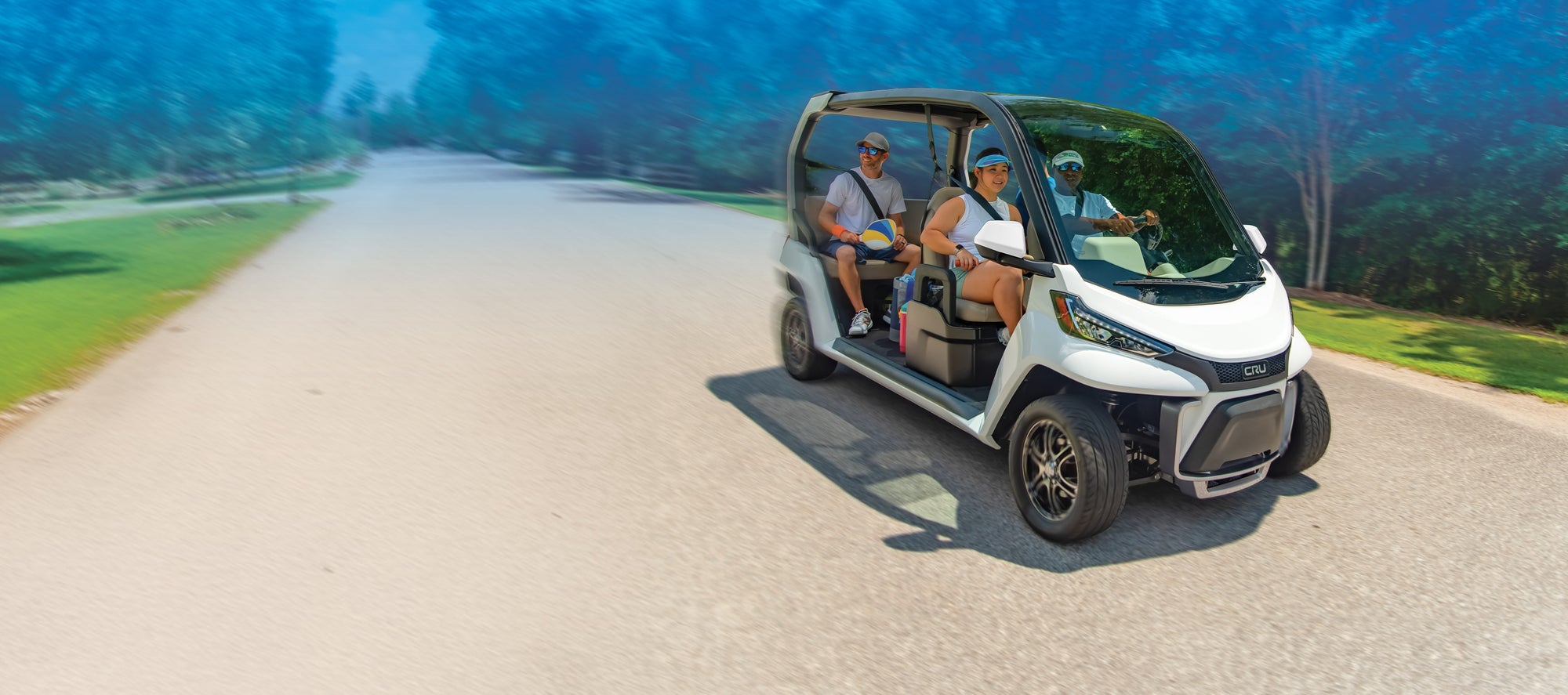 A group of people with pickleball gear ride a Club Car CRU street legal vehicle.