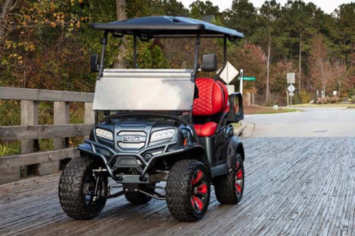 A special edition Club Car golf cart with bright red seats parked outside