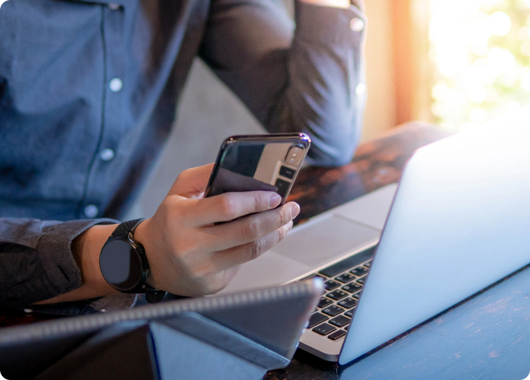 Man holding a credit card near his laptop sitting at a desk