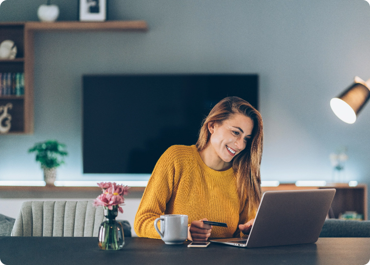 Lady sitting in her home office entering credit card information into a computer 