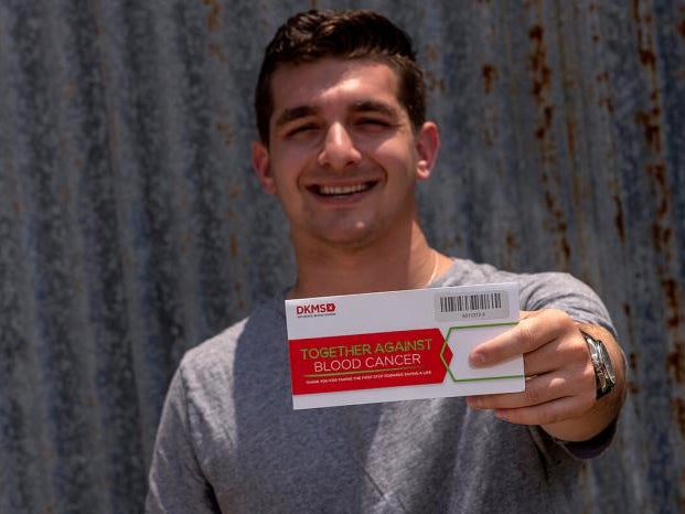 Cody Donor holding DKMS envelope kit Cody Donor holding DKMS envelope kit