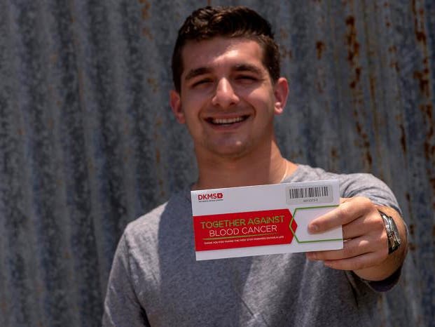 Cody Donor holding DKMS envelope kit Cody Donor holding DKMS envelope kit