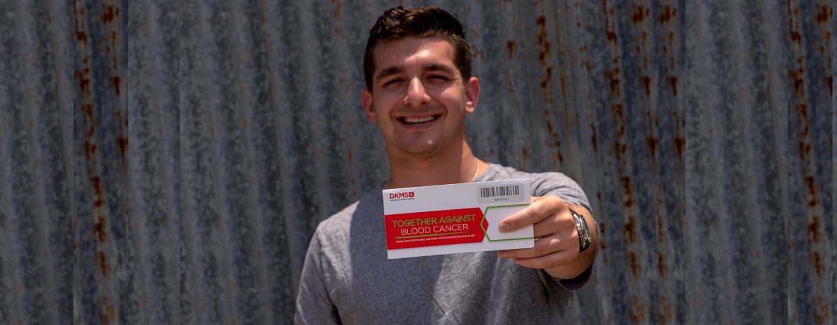 Cody Donor holding DKMS envelope kit