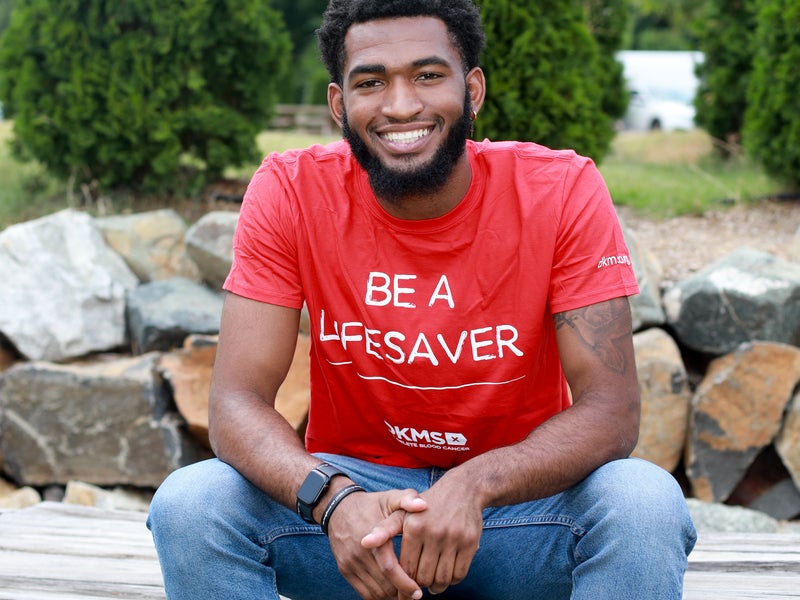 Corey, a registered bone marrow donor, smiles at a donation recruitment event