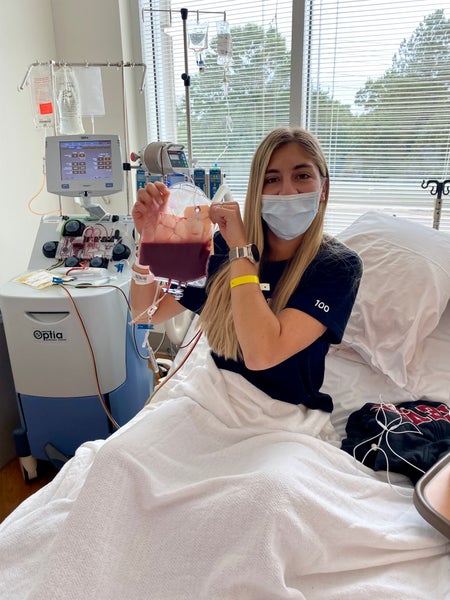 Alanna smiling under her mask holding her stem cell donation
