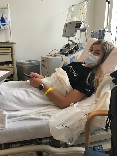 Alanna smiling under her mask while laying in the donation bed, donating stem cells