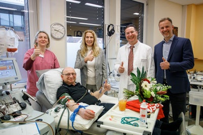 Dr. Elke Neujahr, Global CEO at DKMS, Dr. Gero Hütter, Medical Director of the DKMS Collection Center, Sirko Geist CEO of the DKMS Collection Center (from left to right) welcome Michael Zentgraf, one of the first donors at the DKMS Collection Center.