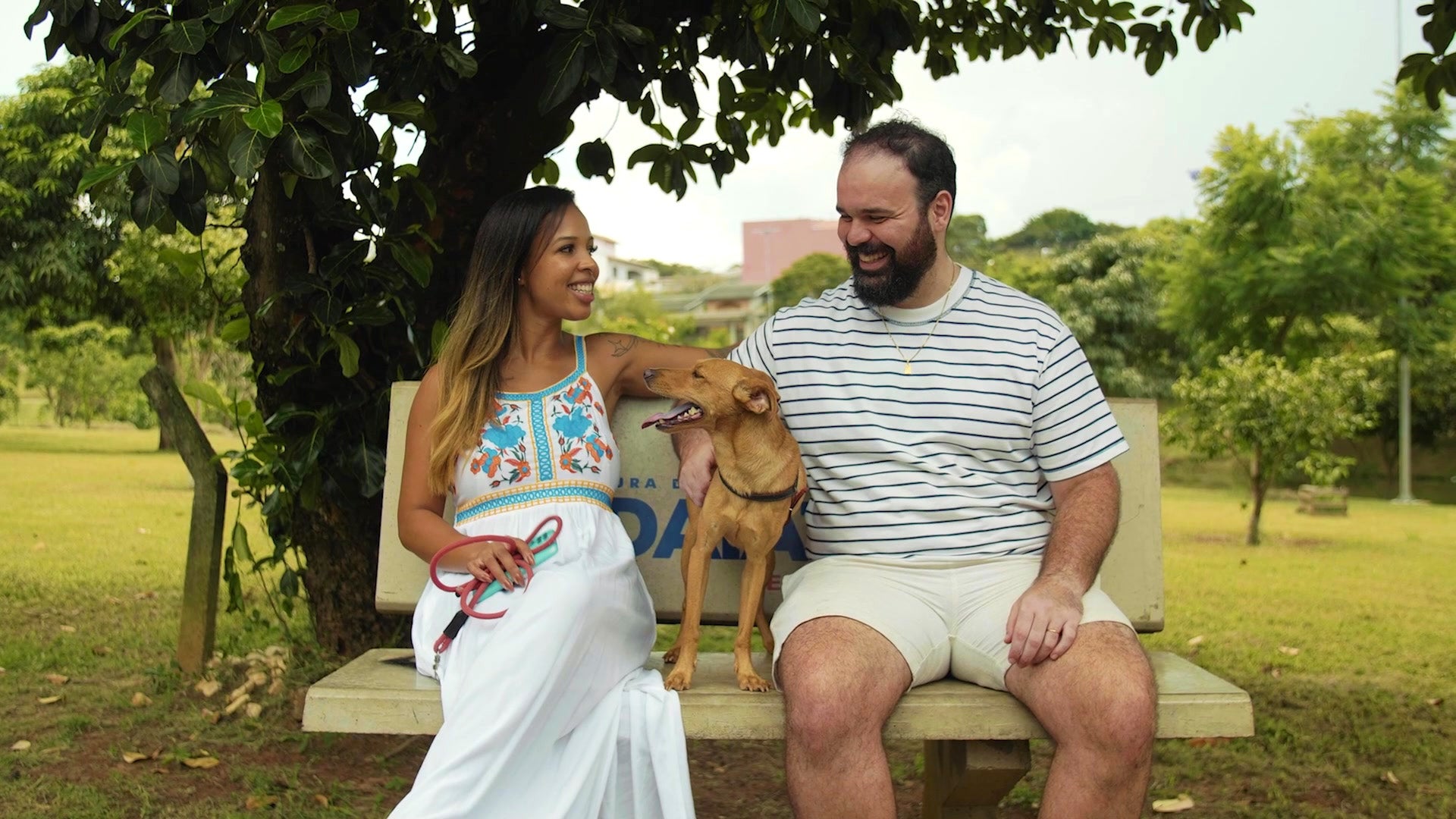 Manuel Da Silva and his wife on a park bench with their dog.
