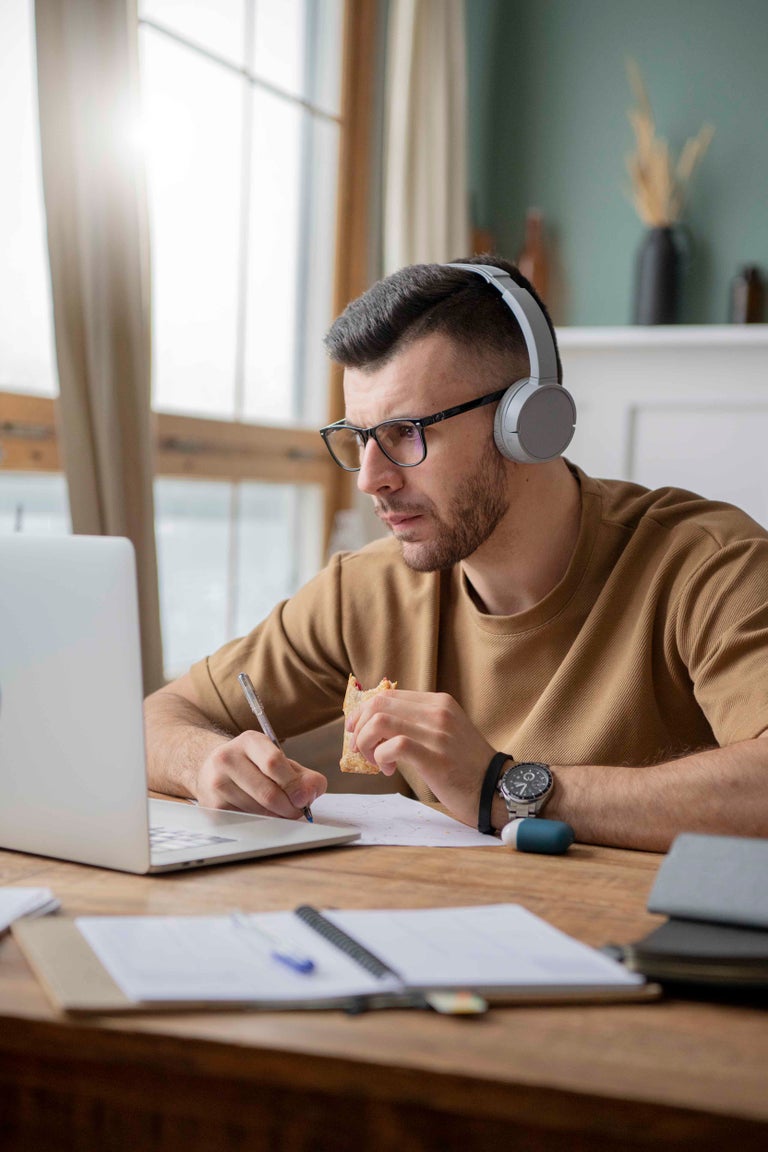 A remote worker is studying at his home desk. 