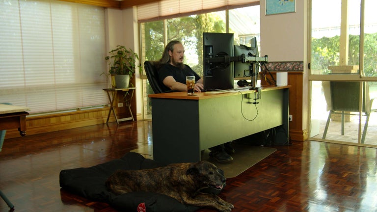 Ben New in his home office with his dog. 