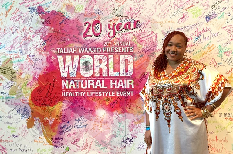 A woman standing in front of a wall with autographed signs