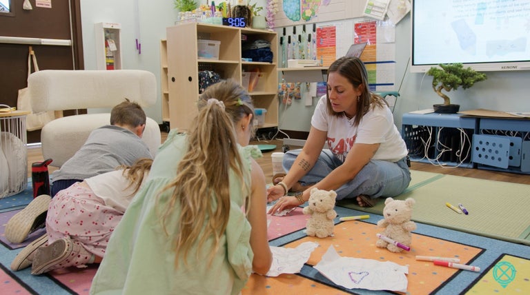 Holly helping a student with their reading.