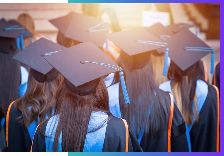 A group of female graduates huddle together.