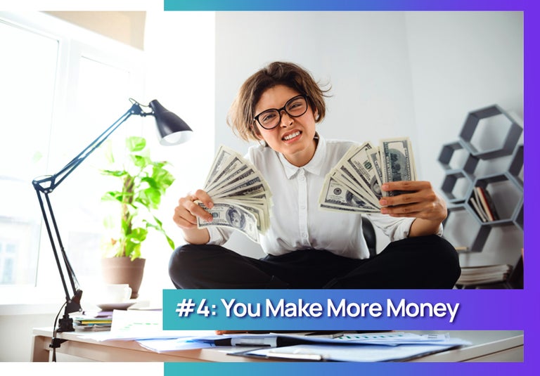 Advantage of contract work is you make more money. Woman on a table holding cash money smiling.