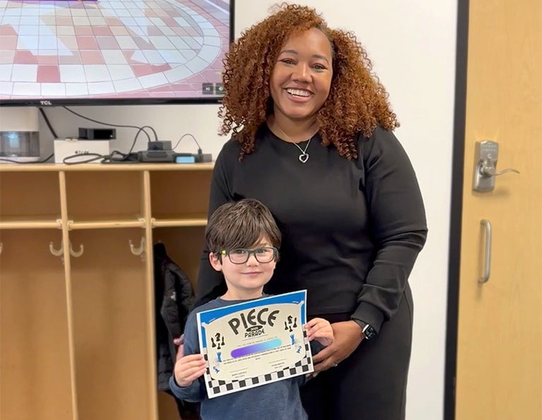 A woman and a boy holding a certificate