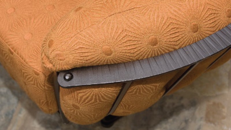Close-up of O.W. Lee orange outdoor chair with hand-sewn fabric & precision-forged metal frames, protected by PPG powder coatings.