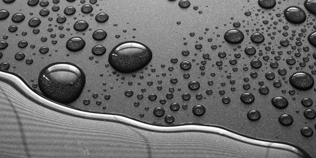 Close-up of oil collecting on non-stick coating in droplets displaying non-stick quality.
