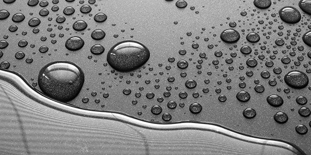 Close-up of gray material with liquid droplets on displaying the properties of PPG's unique nonstick and release coatings.