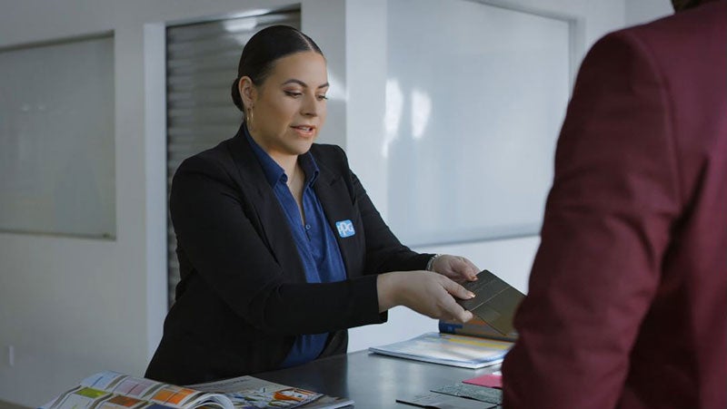 Vanessa Peterson, PPG's US color design manager, wearing a PPG blazer and showing a client color swatches.