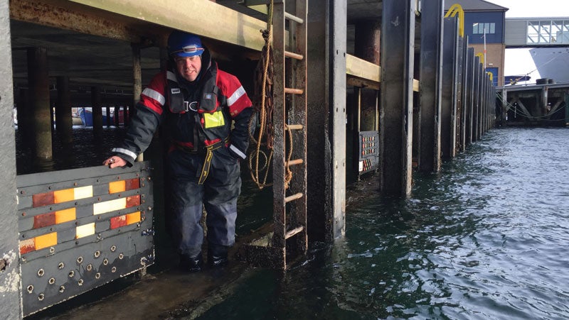 Gareth Berry, PPG industrial coatings' European market specialist, studying the coating test board at low tide in the North Sea.