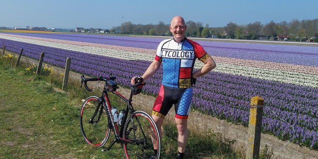 Edwin Verweij, PPG Industrial Coatings' bike segment platform manager, stood near a field of purple, white and pink tulips with his bike.