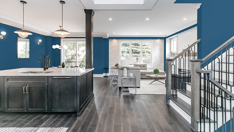 Blue and white living room and kitchen with beige grey wood finishes.