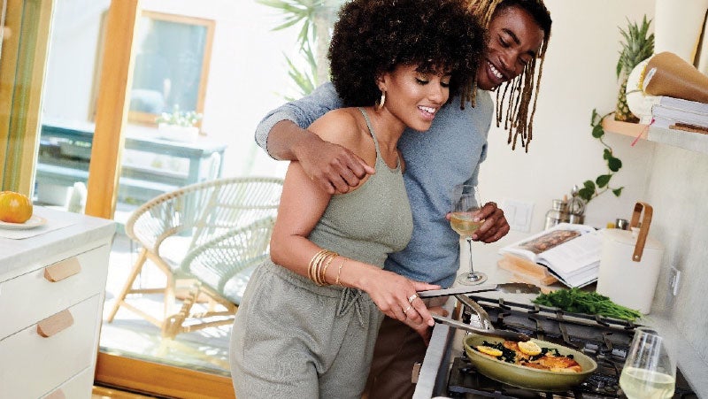 Couple cooking with a colored frypan protected by PPG nonstick coating