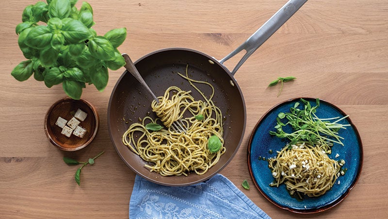 Pesto spaghetti with basil in brown PPG/Whitford nonstick pan, protected from sticking by PPG Eclipse coating