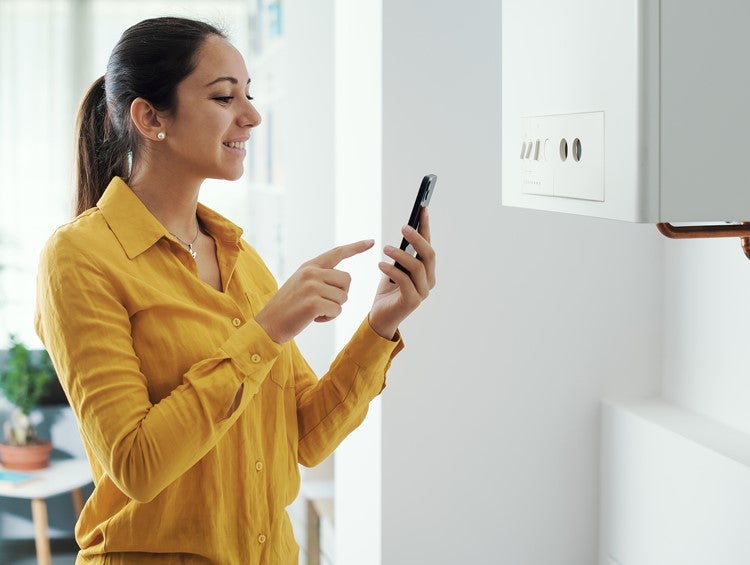 Woman checking boiler setting on mobile phone