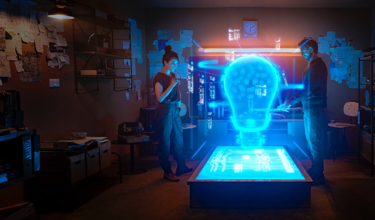 Woman and man looking at hologram of a lightbulb