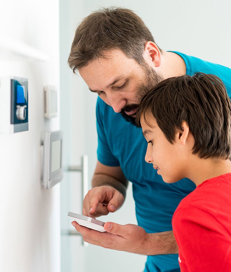 Father and son adjusting smart meter