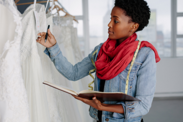 Fashion designer checking stock of dresses