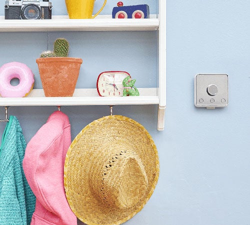 Smart meter on a wall beside shelf.