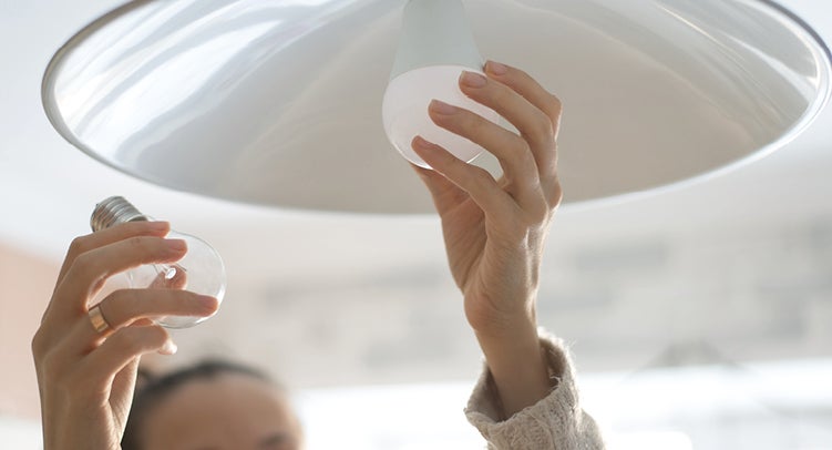 Person changing a light bulb