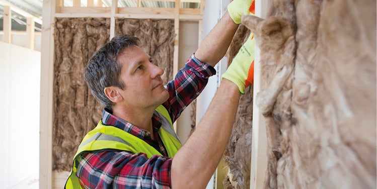 Male worker installing insulation