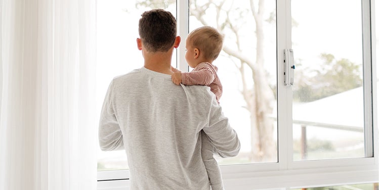 Man and baby looking out window