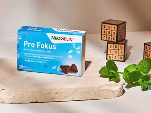 Packung von NeoGelin Pro Fokus, im Hintergrund Würfel mit Zahlen.