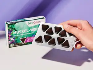 NeoGelin Muskel-Wohl Soft-Tablette in der Hand, im Hintergrund die Verpackung.