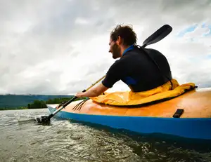 Mann im Kayak im Wasser.