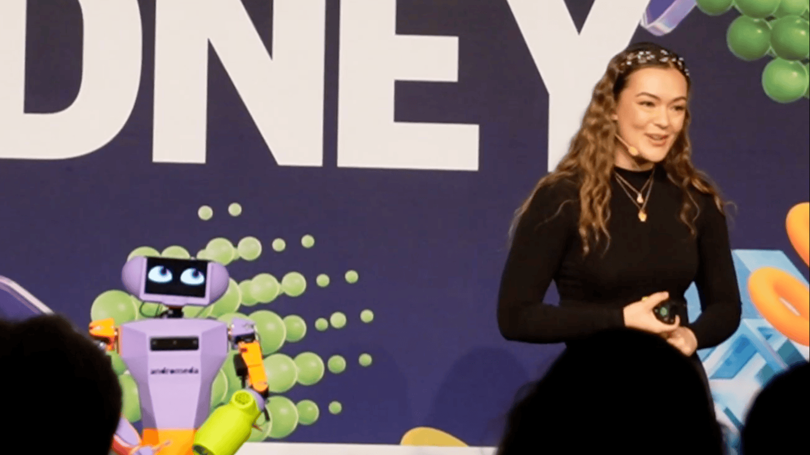 Woman speaking on stage with robot