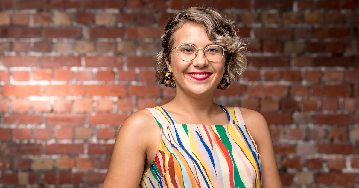 Woman founder smiling infront of wall