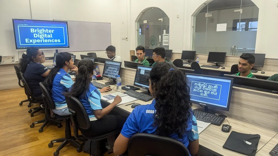 Students at school infront of computers, learning from a presentation screen