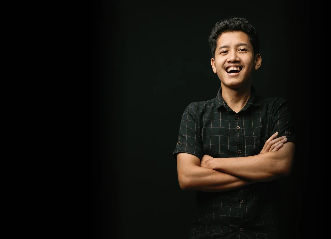 Picture of Haqi laughing against a black background