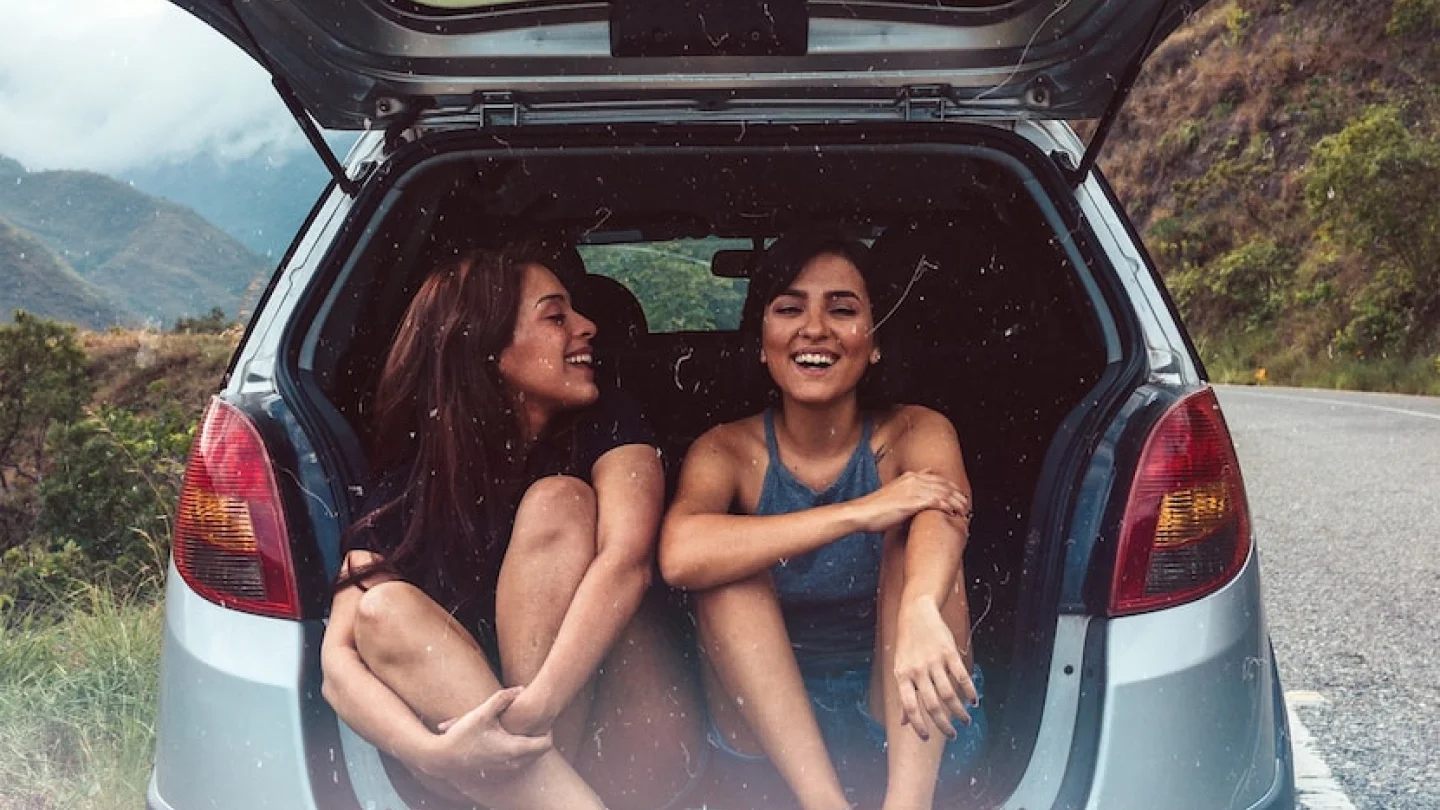 Picture of two women sitting in the boot of a car