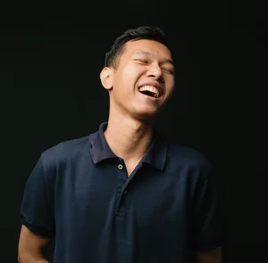 Picture of Artha laughing against a black background