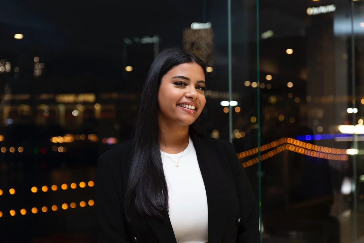 Picture of Chloe Andrews at Luminary birthday event, standing in front of city lights