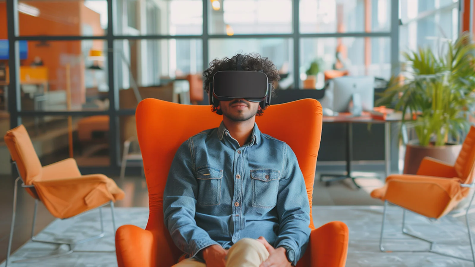Picture of a man with VR glasses in an orange chair