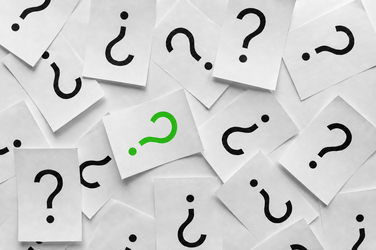 Many black questions mark symbols and 1 green question mark on individual square papers scattered